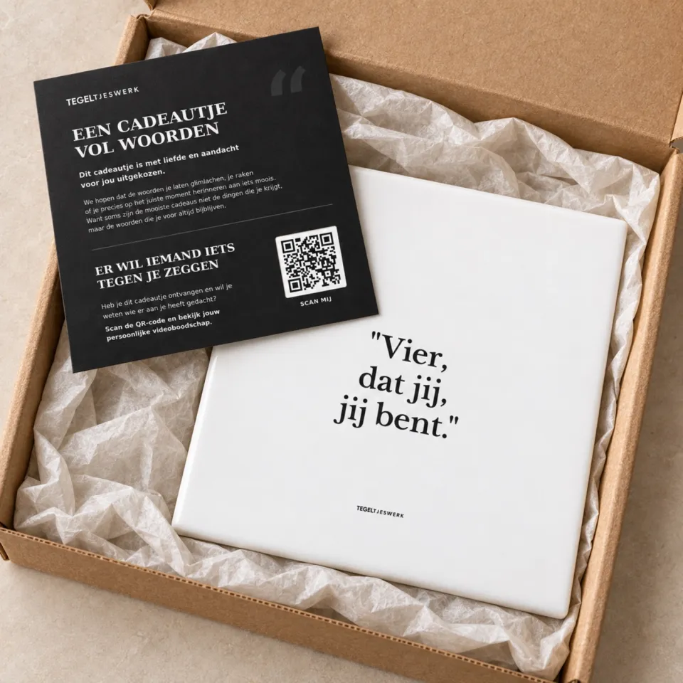 Een geopend pakket met een witte tegel in zijdepapier en een zwarte kaart met QR-code.